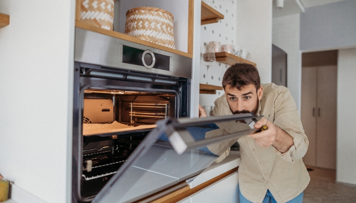 Man double-checking the door seals on his oven