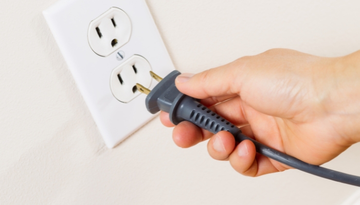 Closeup of a hand plugging in an appliance