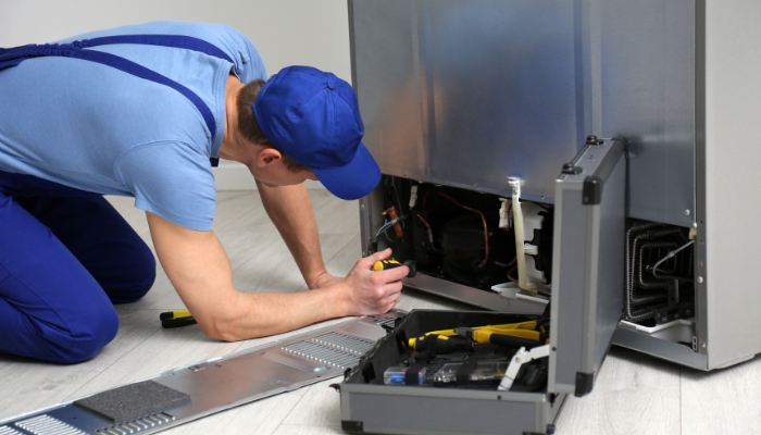 Serv_Refrigerator-Noises_1.jpg Service professional checking the back panel