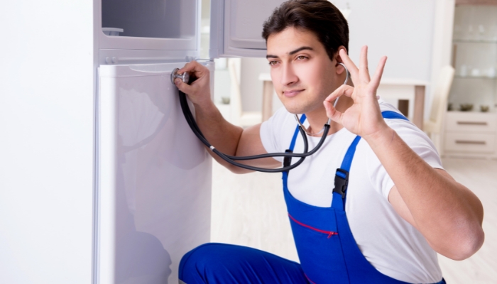 Serv_Refrigerator-Noises_4.jpg Service professional using a stethoscope to listen to the fridge