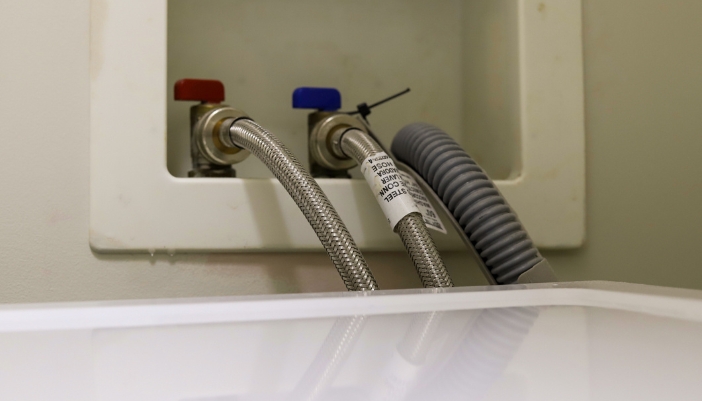 Closeup of the hot and cold water connections for washer machine