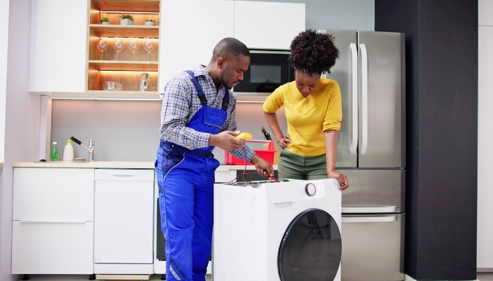  An appliance tech and homeowner troubleshooting the washer machine