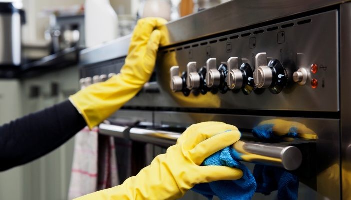 Closeup of someone wiping down a high-end range