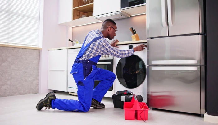Serv_Smart-Laundry-Troubleshooting_4.jpg A service tech fixing a smart all-in-one washer
