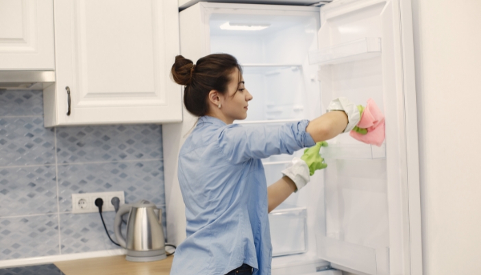 Serv_Summer-Fridge-Optimization_1.jpg Woman cleaning the inside of her fridge