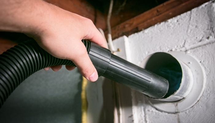 Closeup of someone vacuuming the dryer vent