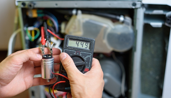 Closeup of a person using a multimeter to check a fuse