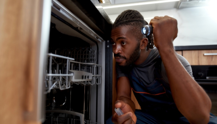Service tech inspecting the inside of the dishwasher
