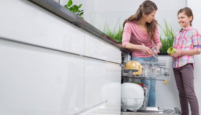 Mother and daughter unloading the dishwasher