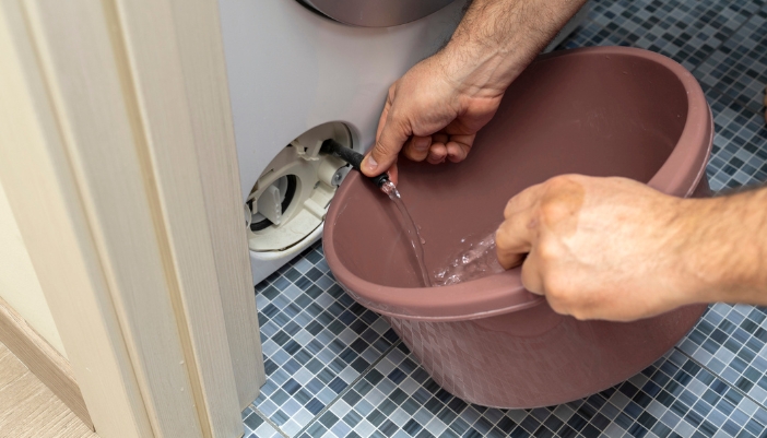 Serv_Dirty-Drain-Pump-Filter_3.jpg Closeup of someone draining their drain pump filter before cleaning