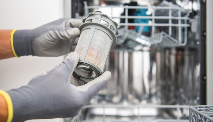 Serv_Good-Appliance-Habits_2.jpg Closeup of someone cleaning the dishwasher filter
