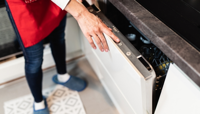 Serv_Good-Appliance-Habits_3.jpg Closeup of someone selecting the right dishwasher cycle