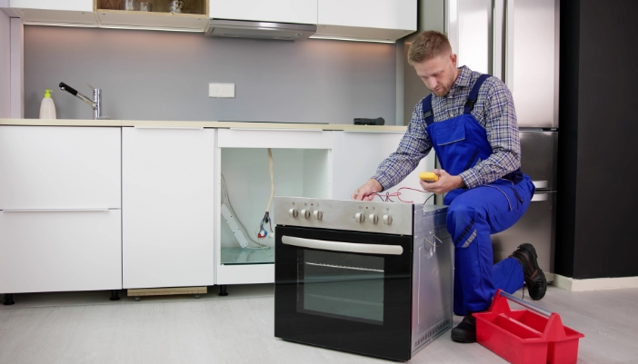 Serv_Good-Appliance-Habits_4.jpg An appliance tech is calibrating an oven