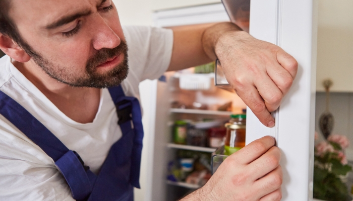 Service technician investigating the door seals on a refrigerator