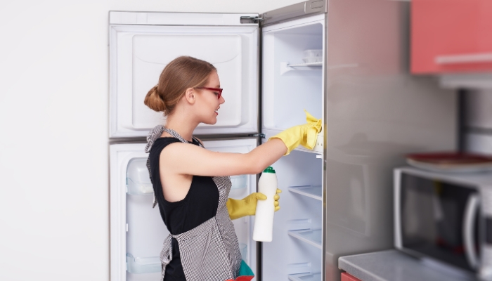 Serv_Fresh-Fridge-Steps_1.jpg Woman doing a deep clean of her fridge