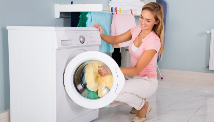 Woman loading washing machine with clothes