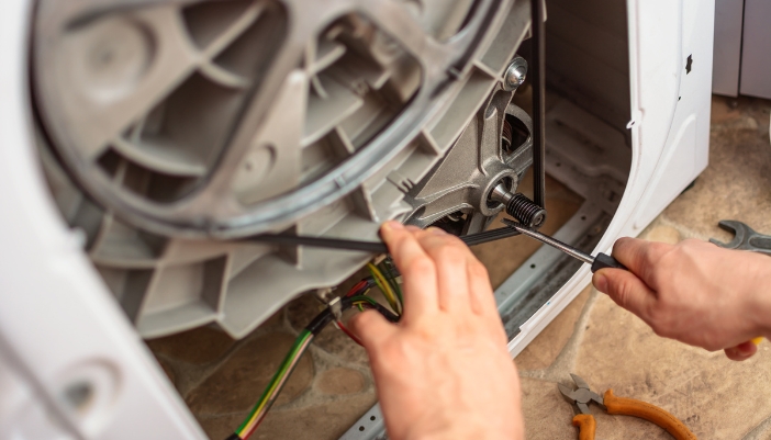 Closeup of service repairmen working on the washing machine bearings