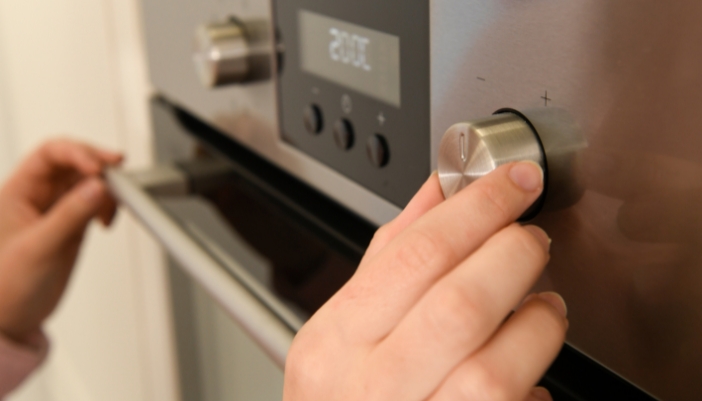 Closeup of someone setting the temperature on a wall oven