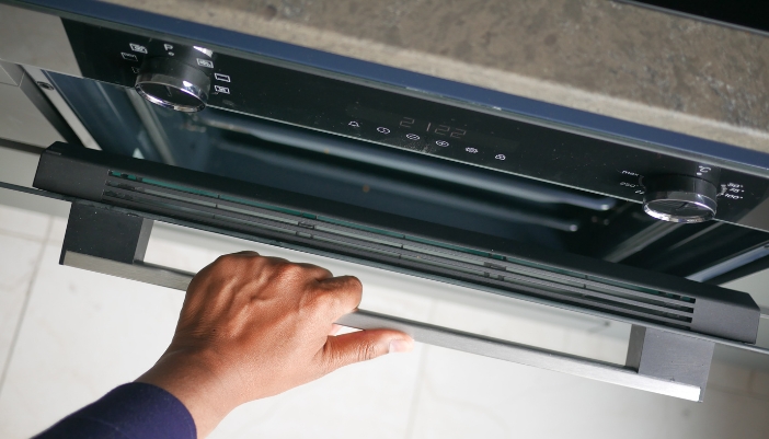 Closeup of someone opening the wall oven door