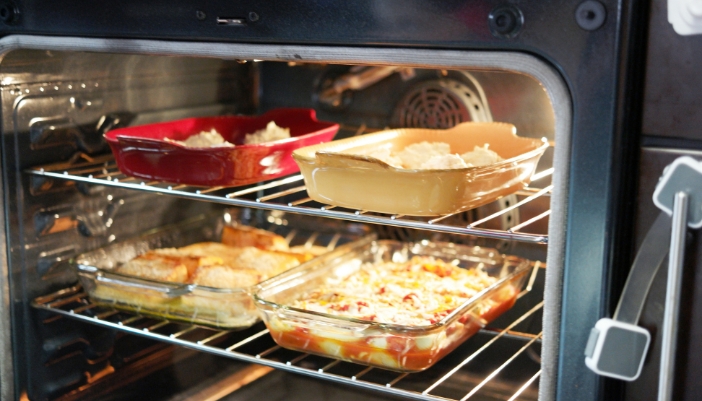 Closeup of dishes cooking with the oven light on