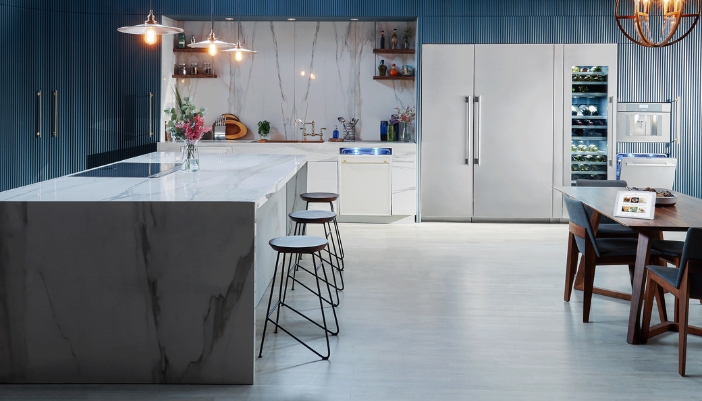 A dimly lit luxury kitchen with stainless steel appliances.