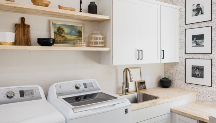 A modern laundry room with white appliances featured.