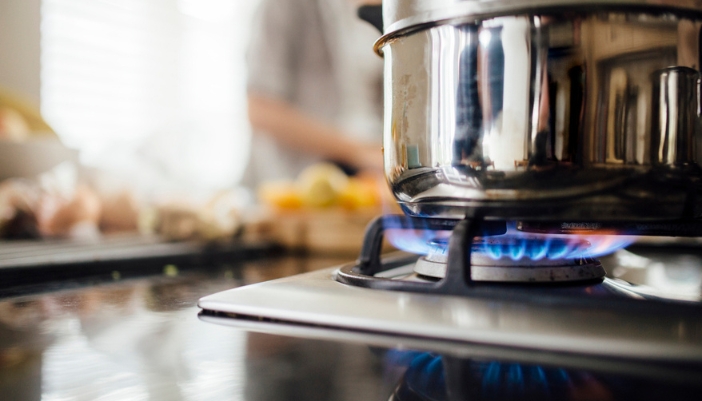 Side-by-side induction and gas ranges in a modern kitchen showroom display