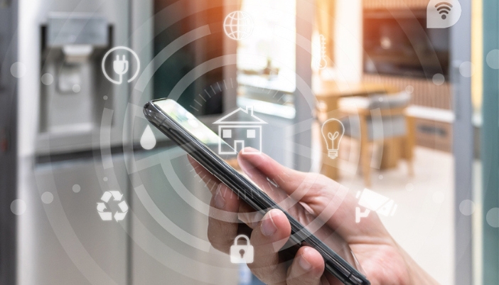 A hand holds a phone with illustrations around it to imply connected appliances.