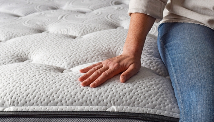 Person sleeping peacefully in a comfortable, well-made bed