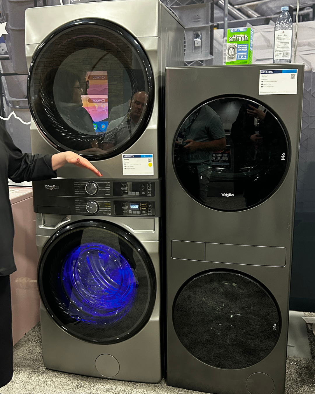 whirlpool stacked laundry washer and dryer towers shown side by side with blue UV light feature turned on