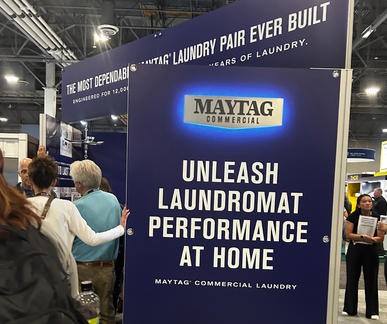 signage in maytag booth for the new commercial laundry launch, sign reads unleash laundromat performance at home