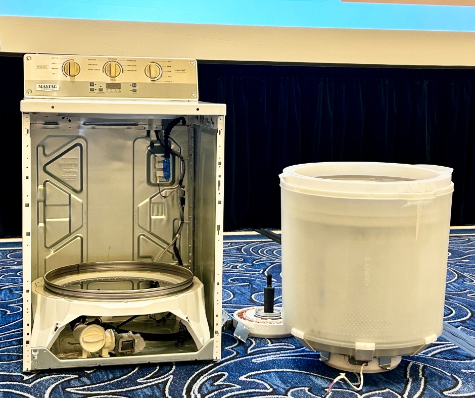 Maytag commercial laundry shown with front access panel removed and drum and wash system pulled for service
