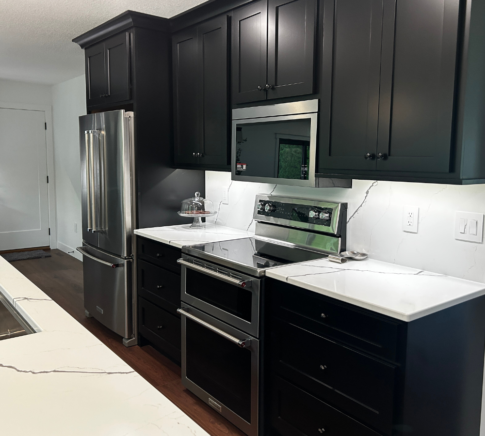 cooking wall in kitchen design including double oven range, microwave hood, and counter depth stainless steel refrigerator