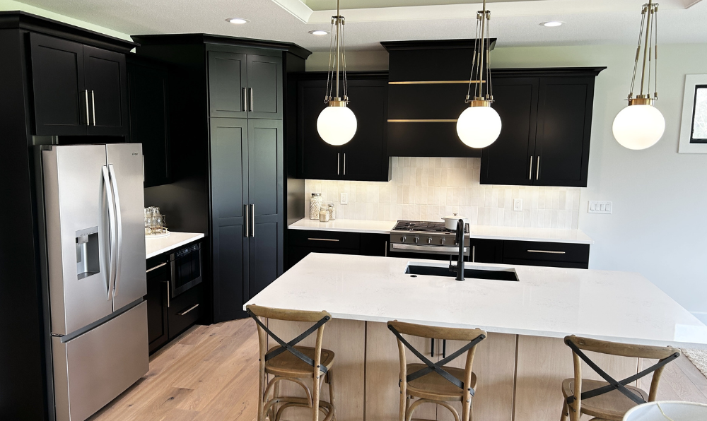 image of kitchen island with sink and pendant lights. Kitchen design by village home stores for advance homes of the quad cities