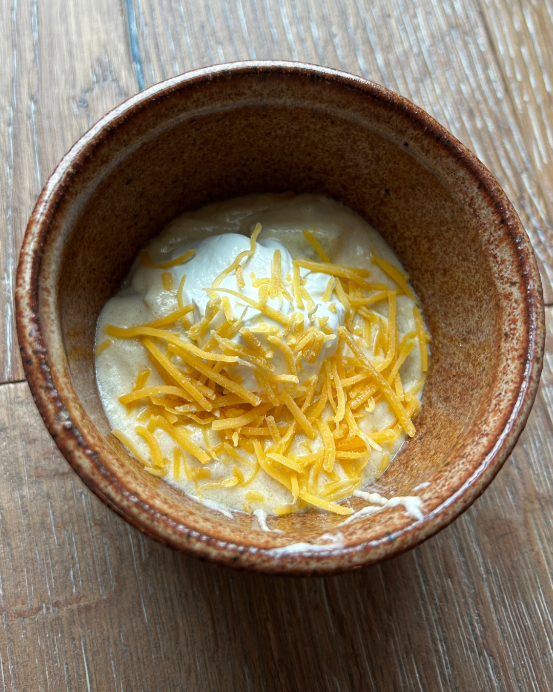 bowl of loaded baked potato soup with sour cream and cheese toppings