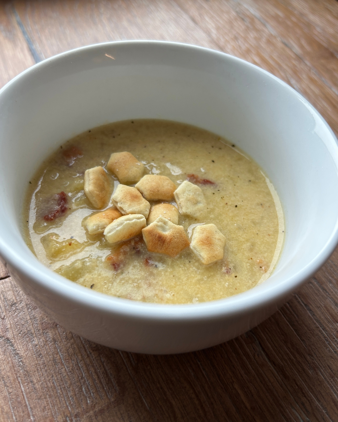 bowl of loaded baked potato soup with soup crackers in it