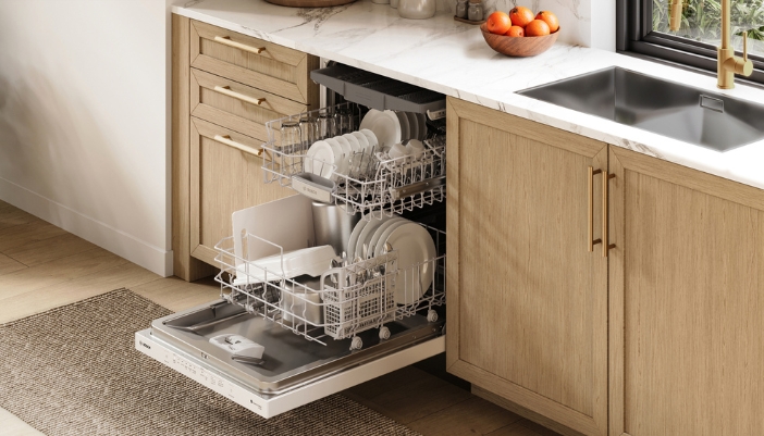 An open Bosch dishwasher in a modern kitchen with tan cabinets.