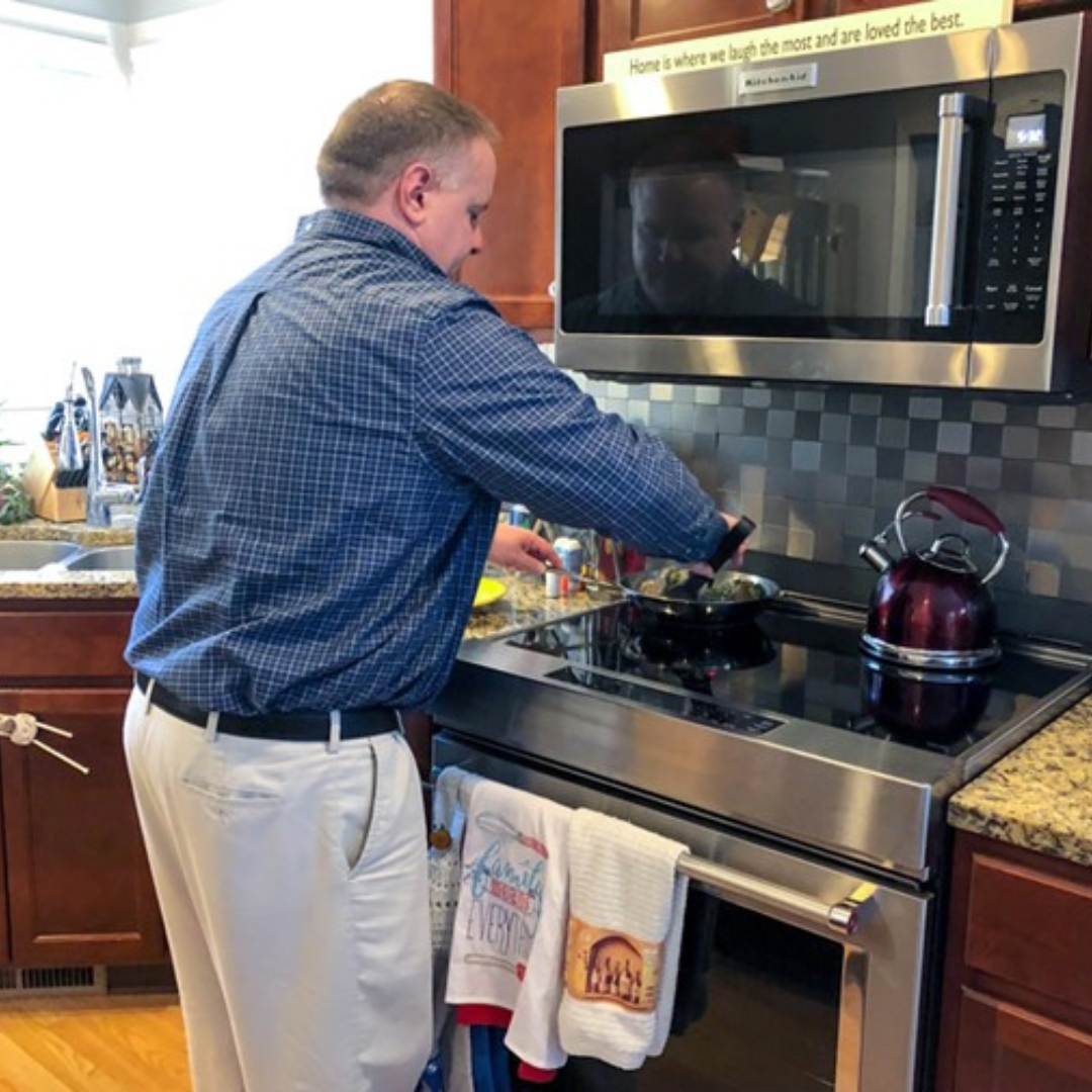A man cooks a meal at his induction range at home.
