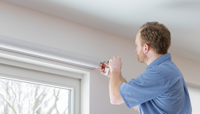 A technician installs smart shades in a modern home.