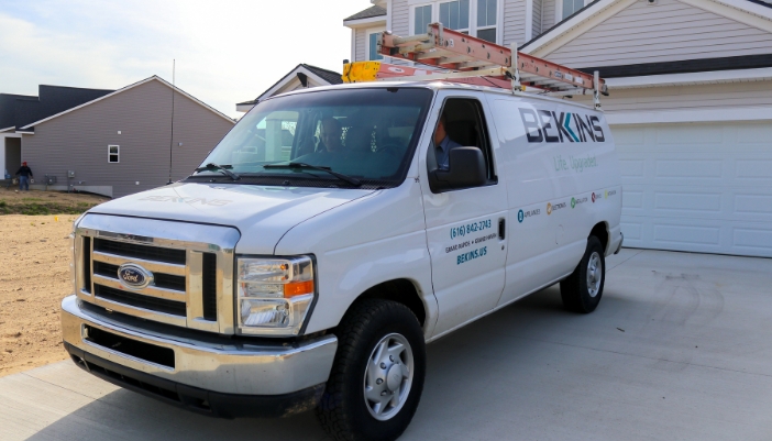 A Bekins van sits outside the garage of a modern home.