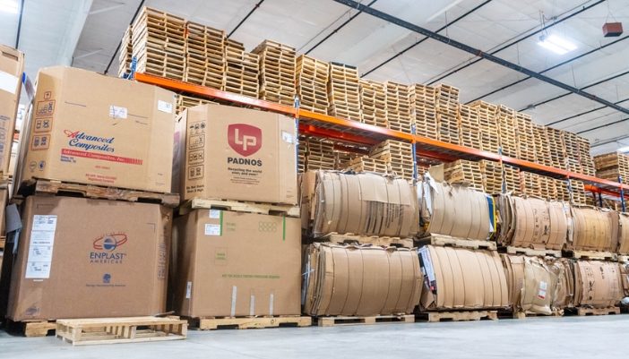 Pallets of recycled materials loaded in a warehouse.