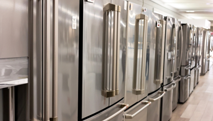 An appliance showroom of a line of fridges