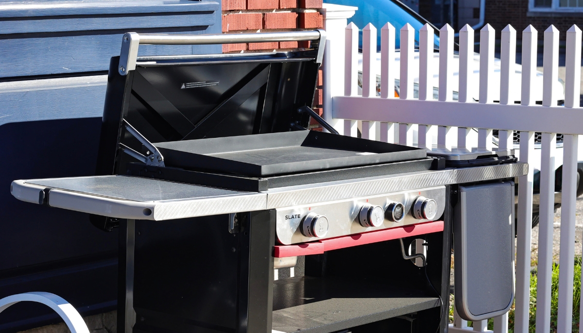Wireless meat thermometer probe inserted into food cooking on a smart grill