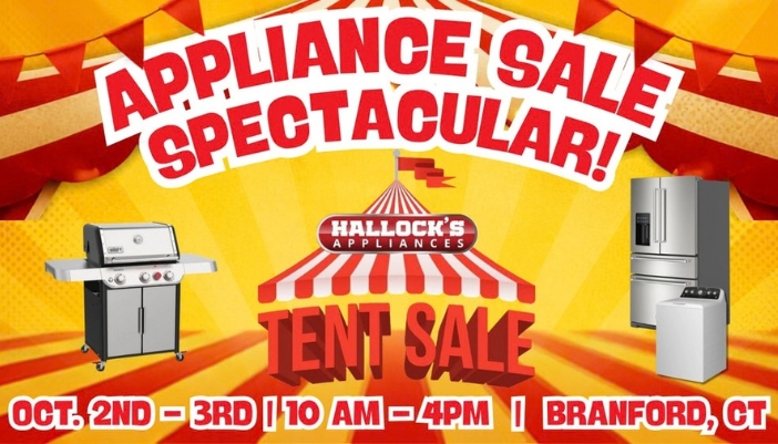 Rows of discounted kitchen and laundry appliances on display under a large tent at an outdoor appliance sale