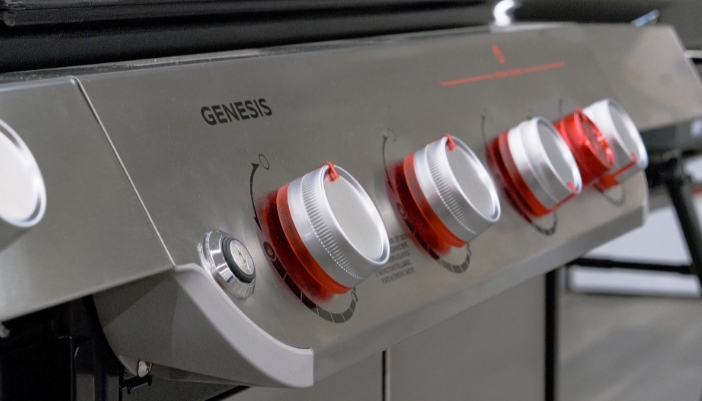 A close-up of knobs on an outdoor grill.