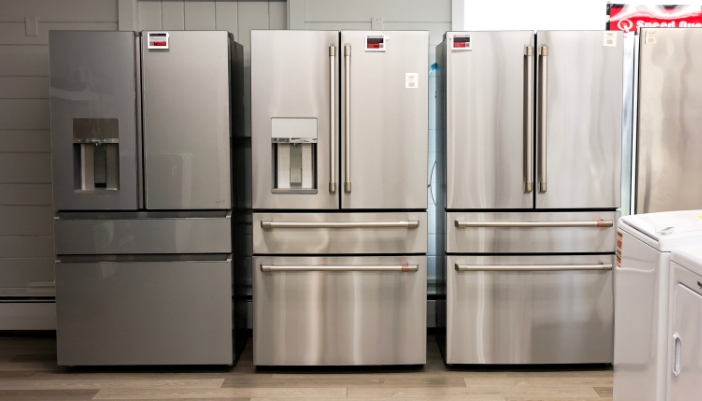 Three stainless steel fridges side-by-side in an appliance showroom.
