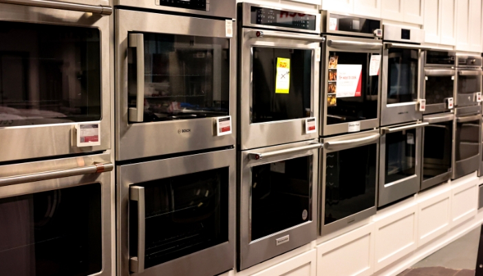 A selection of wall ovens in an appliance showroom.