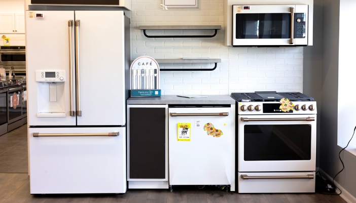 A line of white Cafe appliances in a showroom.