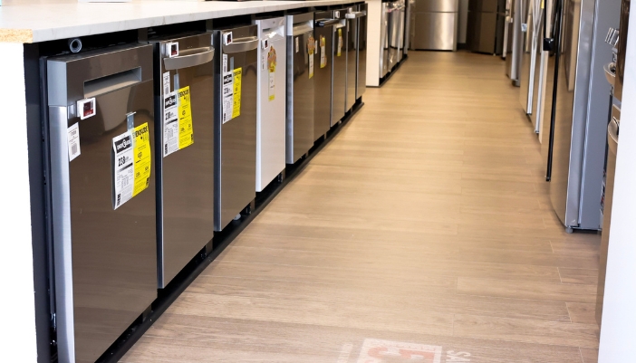 A line of dishwashers in a showroom.