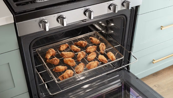 Plain chicken wings in a basket in an air fryer range.